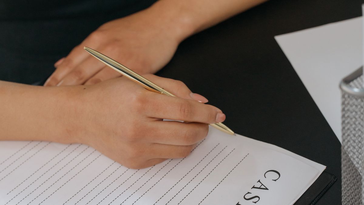 Hand writing on a document with a pen