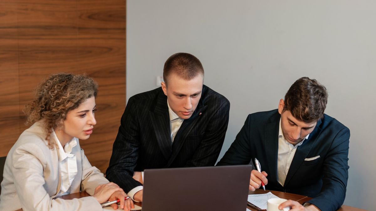 Colleagues reviewing a laptop during a meeting